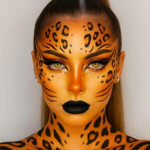 Fierce tiger-inspired makeup with orange and black animal print patterns by Vizio Makeup Academy.