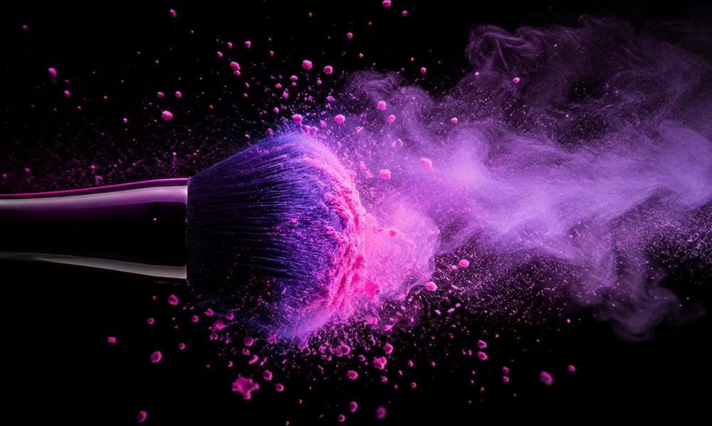 Professional makeup brush moving through colorful cosmetic powder